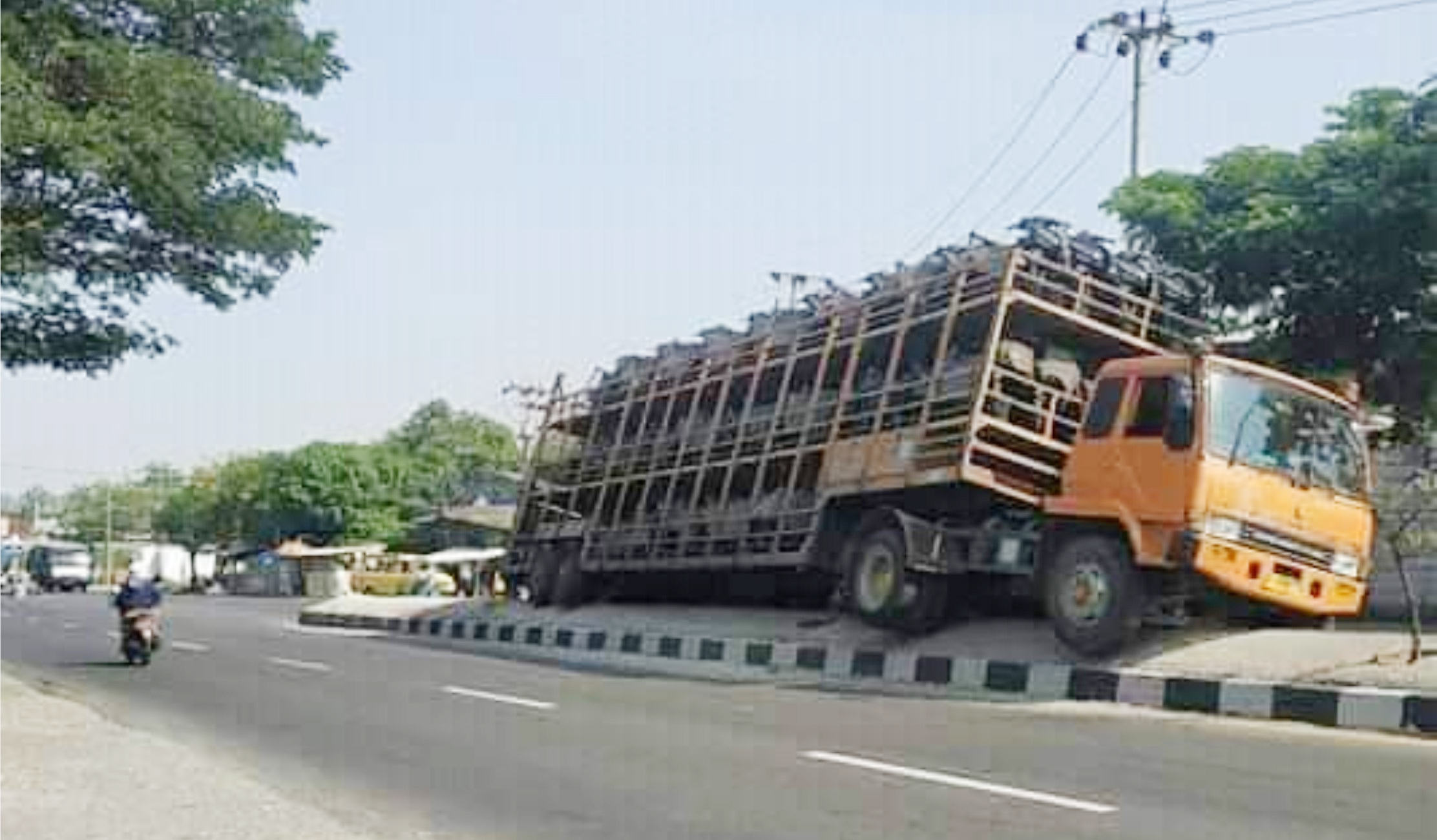 Truk Tronton Bermuatan Sepeda Motor Nangkring di Median Jalan