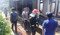 Petugas Damkar dibantu polisi memastikan kebakaran yang menghanguskan dua rumah warga Desa Lebakmekar, Kecamatan Greged, Kabupaten Cirebon, benar-benar padam, Rabu (27/7/2022).* Foto: Istimewa